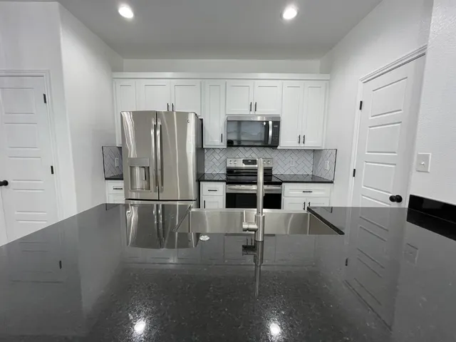 a kitchen with stainless steel appliances a refrigerator and microwave