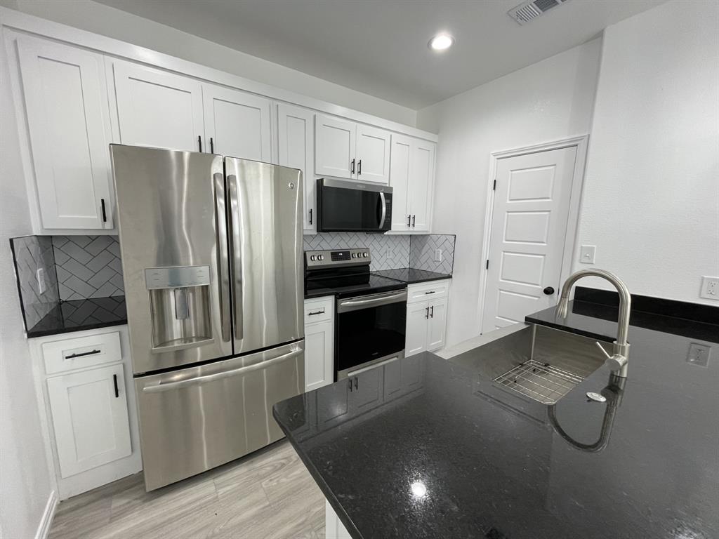 3309 Collin Street Fort Worth, TX 76119 - Photo 4 of 15 a kitchen with a refrigerator sink and cabinets