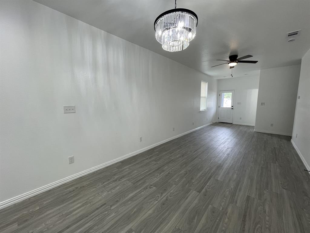 3309 Collin Street Fort Worth, TX 76119 - Photo 6 of 15 an empty room with wooden floor and windows