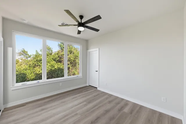 a view of a big room with wooden floor closet and windows