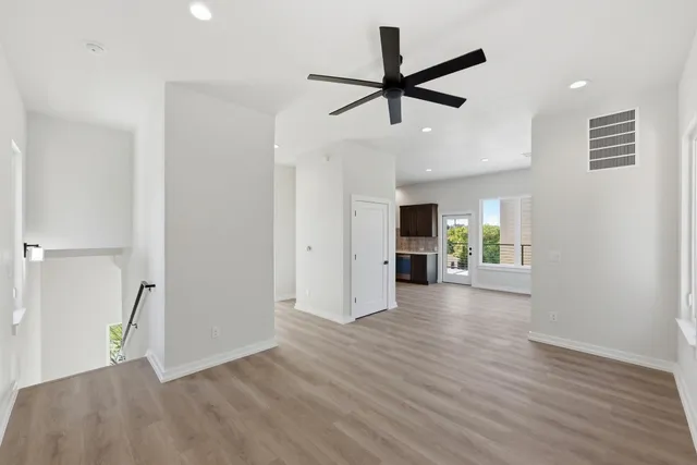 a view of a livingroom with wooden floor and a ceiling fan