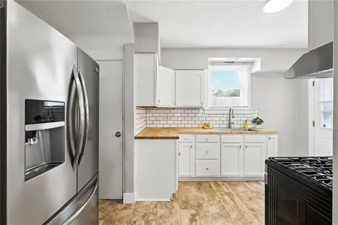 a kitchen with granite countertop a refrigerator stove and sink