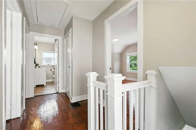 a view of a hallway with wooden floor and stairs