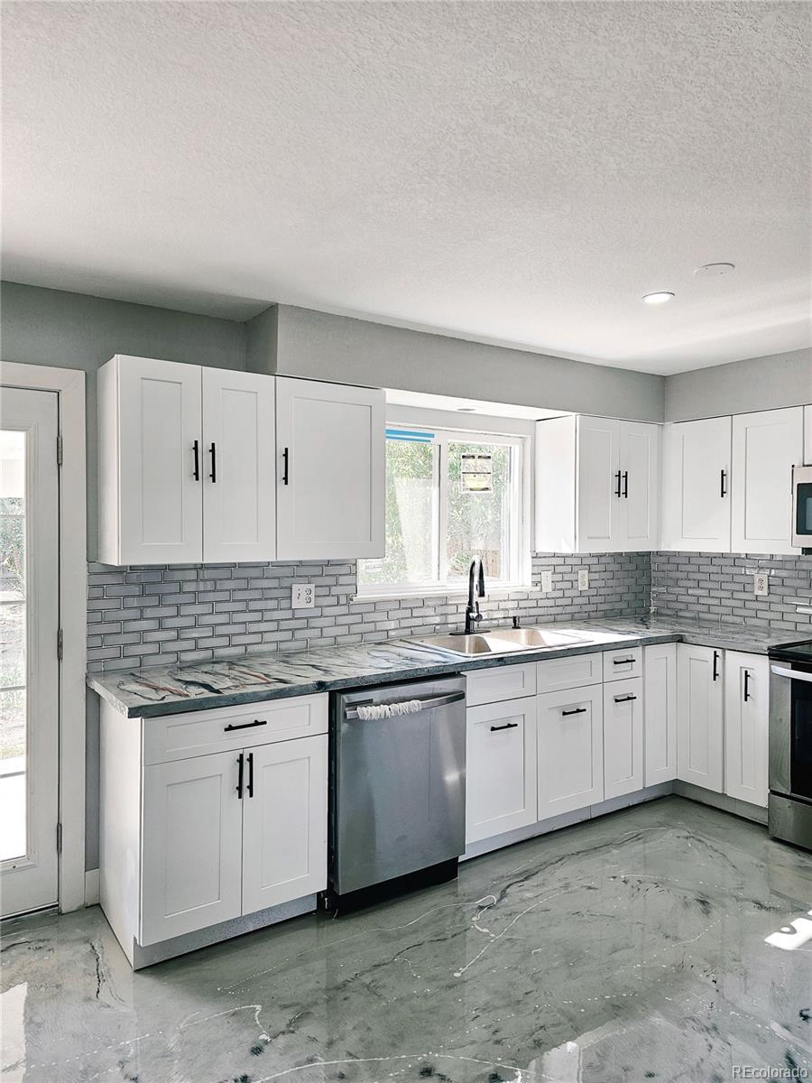 4716 Freeport Way Denver, CO 80239 - Photo 22 of 29 a large kitchen with granite countertop a sink and dishwasher a stove with wooden floor