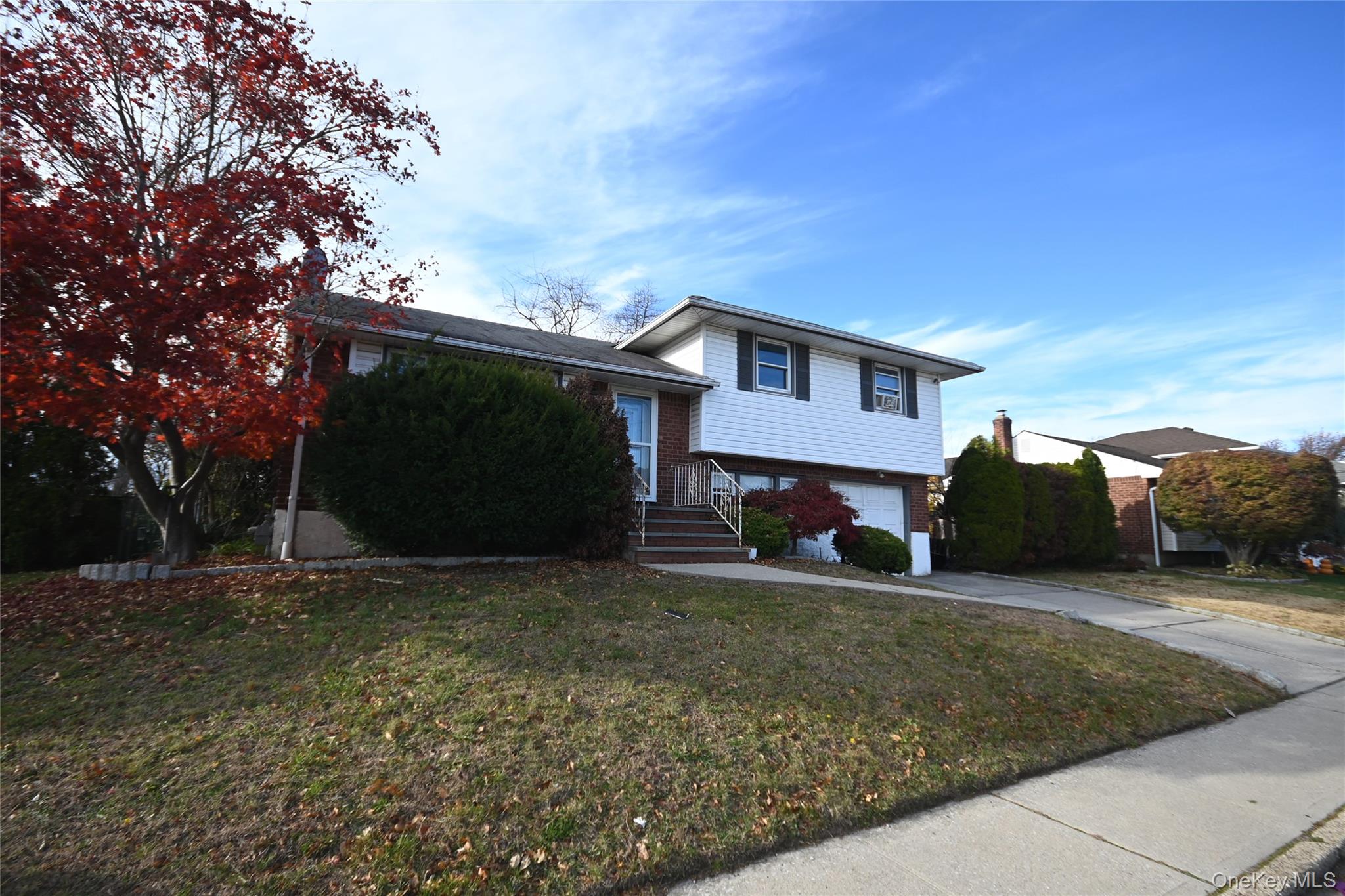89 Osborne Road West Hempstead, NY 11552 - Photo 3 of 50 Split level home with brick siding, driveway, a front lawn, and an attached garage