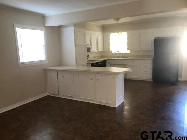 a kitchen with a sink cabinets and a window