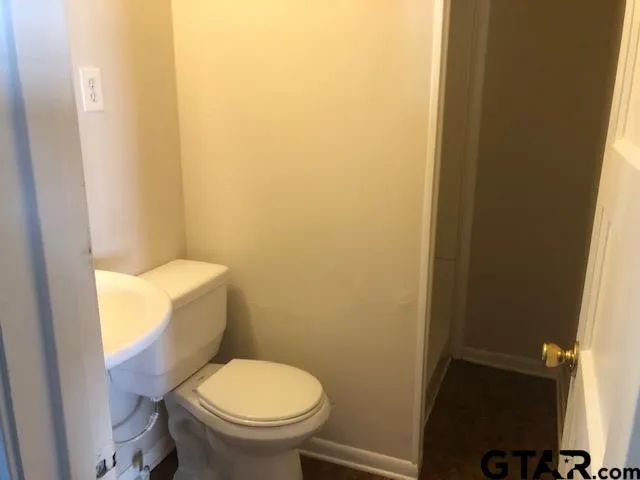 a white toilet sitting next to a small window