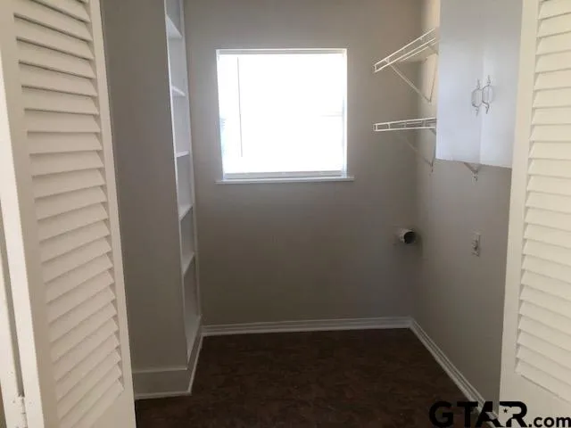 a view of a small space with wooden floor and a window