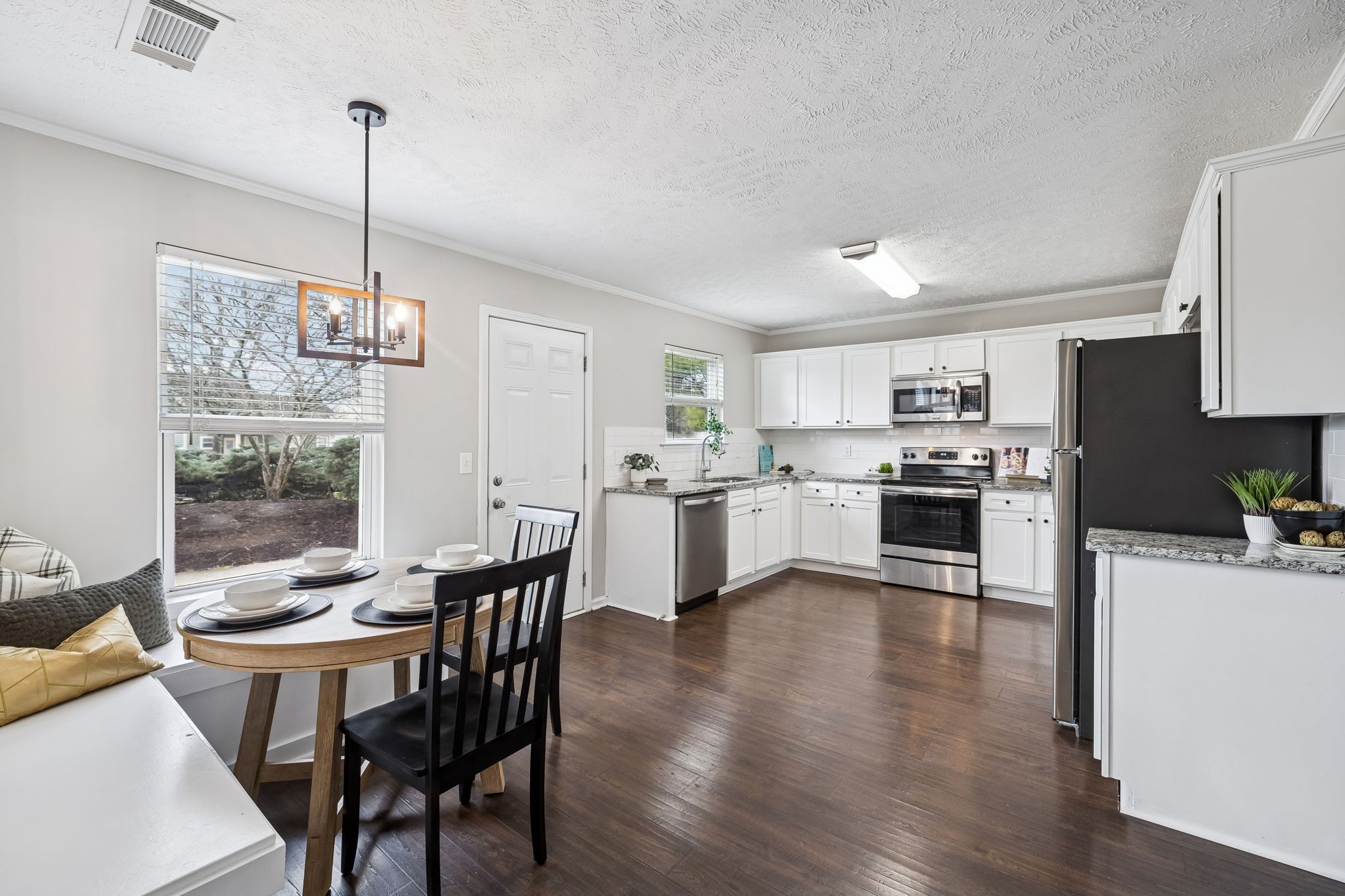 5807 Roxbury Drive Murfreesboro, TN 37128 - Photo 23 of 99 a kitchen with stainless steel appliances granite countertop a stove top oven a sink dishwasher a dining table and chairs with wooden floor