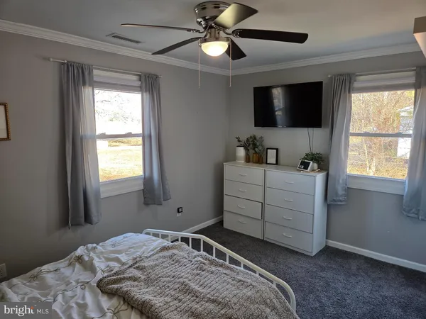 a bedroom with a bed and a flat tv screen on dresser