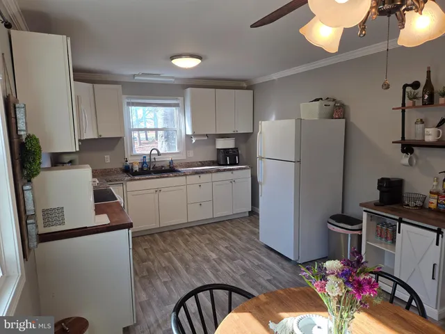 a kitchen with stainless steel appliances granite countertop a refrigerator sink stove and white cabinets