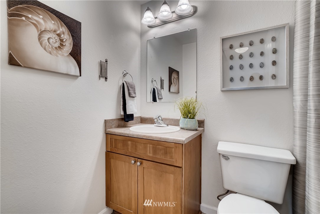 10831 Northeast 147th Lane, Unit R201 Bothell, WA 98011 - Photo 13 of 17 a bathroom with a toilet sink and mirror