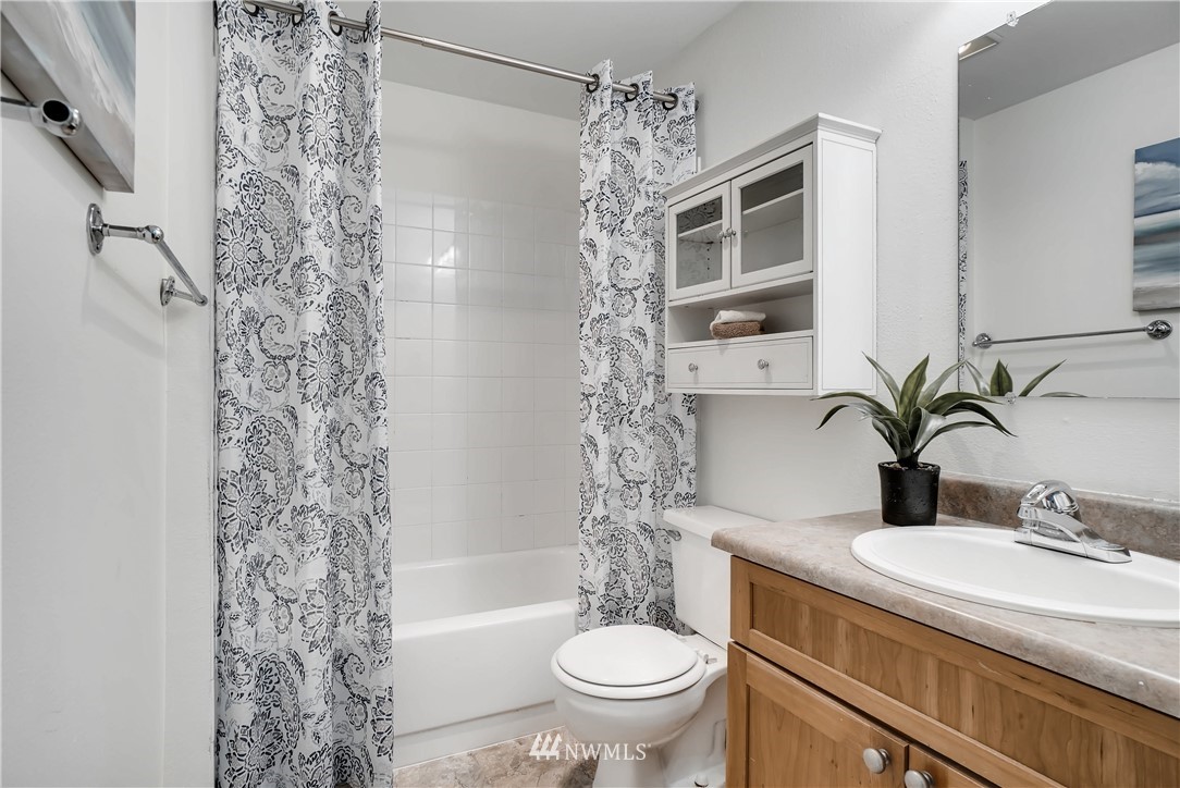 10831 Northeast 147th Lane, Unit R201 Bothell, WA 98011 - Photo 15 of 17 a bathroom with a granite countertop sink toilet and shower