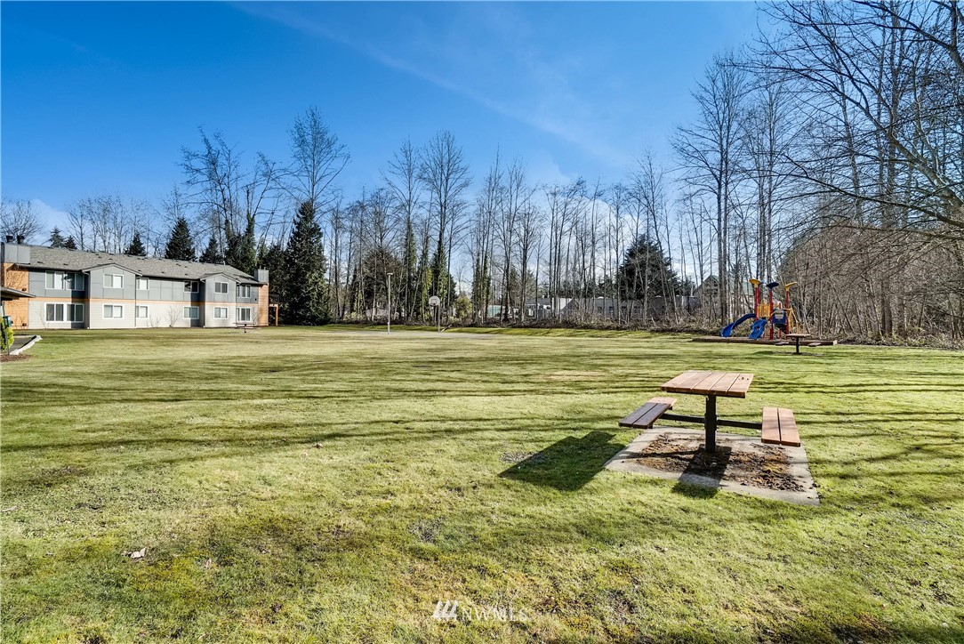 10831 Northeast 147th Lane, Unit R201 Bothell, WA 98011 - Photo 17 of 17 a view of a pool with lawn chairs and large trees
