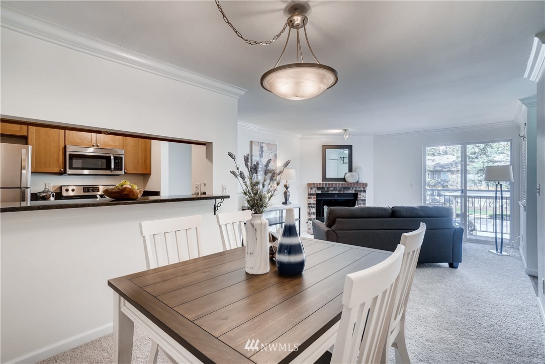 10831 Northeast 147th Lane, Unit R201 Bothell, WA 98011 - Photo 6 of 17 a kitchen with stainless steel appliances granite countertop a stove a kitchen island a stove a table and chairs