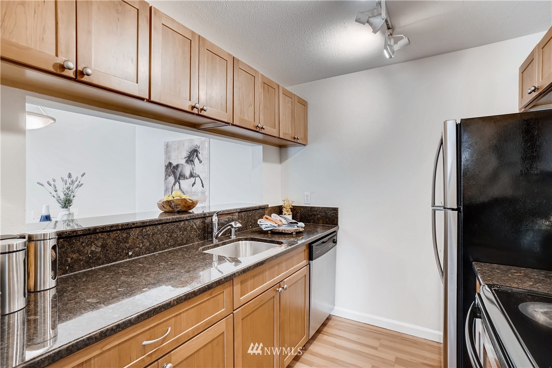 10831 Northeast 147th Lane, Unit R201 Bothell, WA 98011 - Photo 7 of 17 a kitchen with stainless steel appliances granite countertop a sink stove and refrigerator