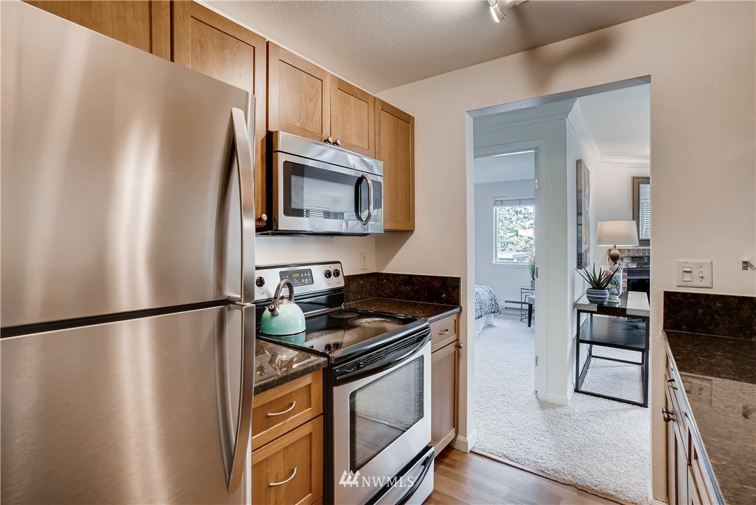 10831 Northeast 147th Lane, Unit R201 Bothell, WA 98011 - Photo 8 of 17 a kitchen with stainless steel appliances granite countertop a refrigerator stove and microwave
