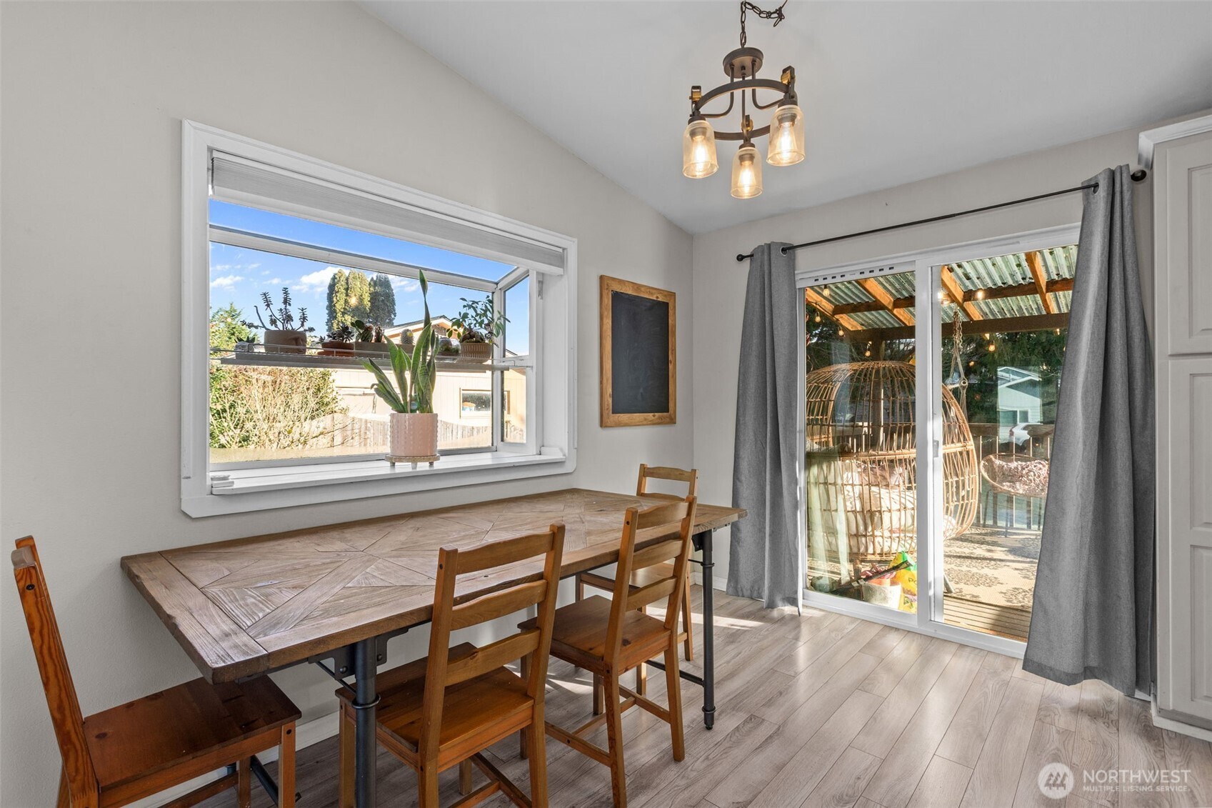 20911 Ronning Road Arlington, WA 98223 - Photo 7 of 40 a dining room with wooden floor a chandelier a glass table and chairs