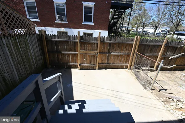 a view of backyard with wooden wall and a potted plant