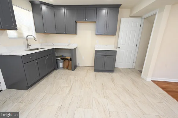 a kitchen with a sink a refrigerator and cabinets