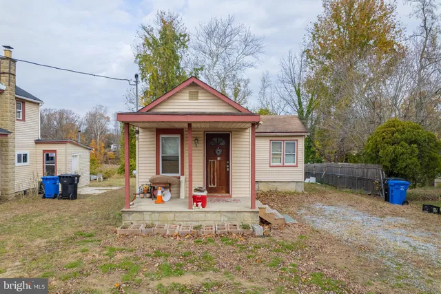 a view of a house with a yard and large tree