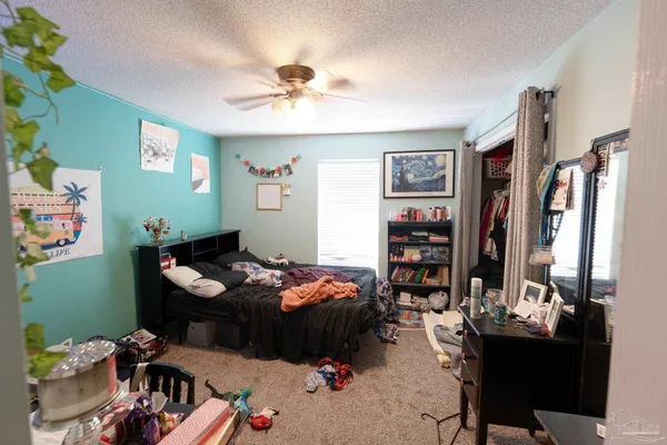 a bedroom with a bed couch and a chandelier