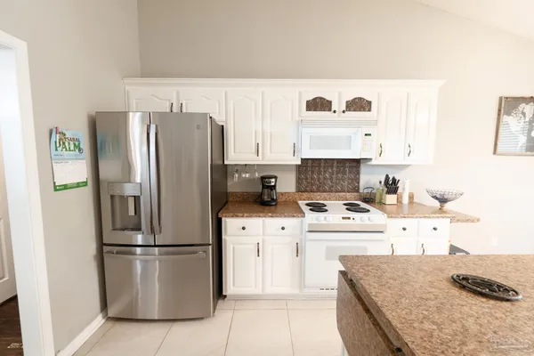 a kitchen with granite countertop a sink stove and refrigerator