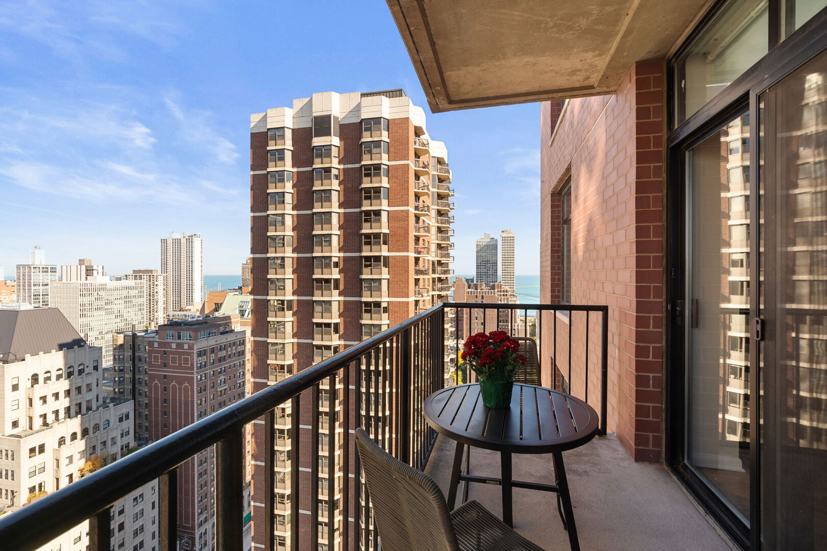 1122 North Dearborn Street, Unit 25H Chicago, IL 60610 - Photo 20 of 30 a view of a balcony with a table and chairs and wooden floor