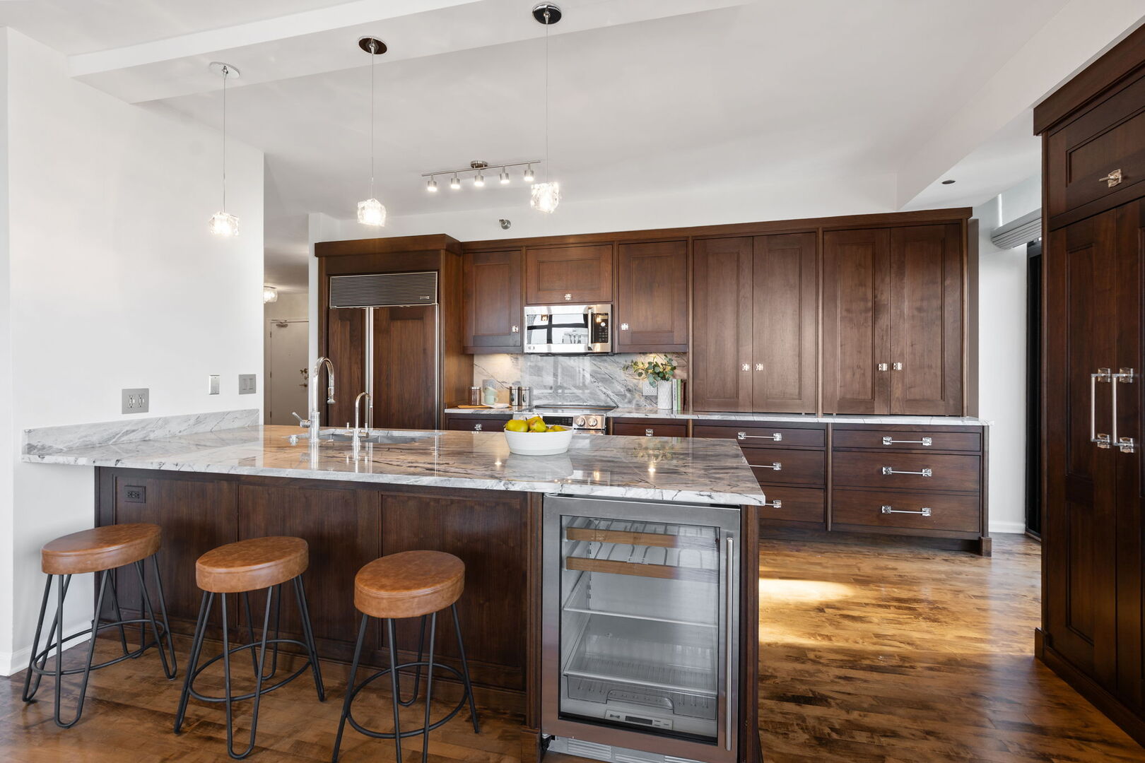 1122 North Dearborn Street, Unit 25H Chicago, IL 60610 - Photo 6 of 30 a kitchen with kitchen island granite countertop a table chairs sink and cabinets