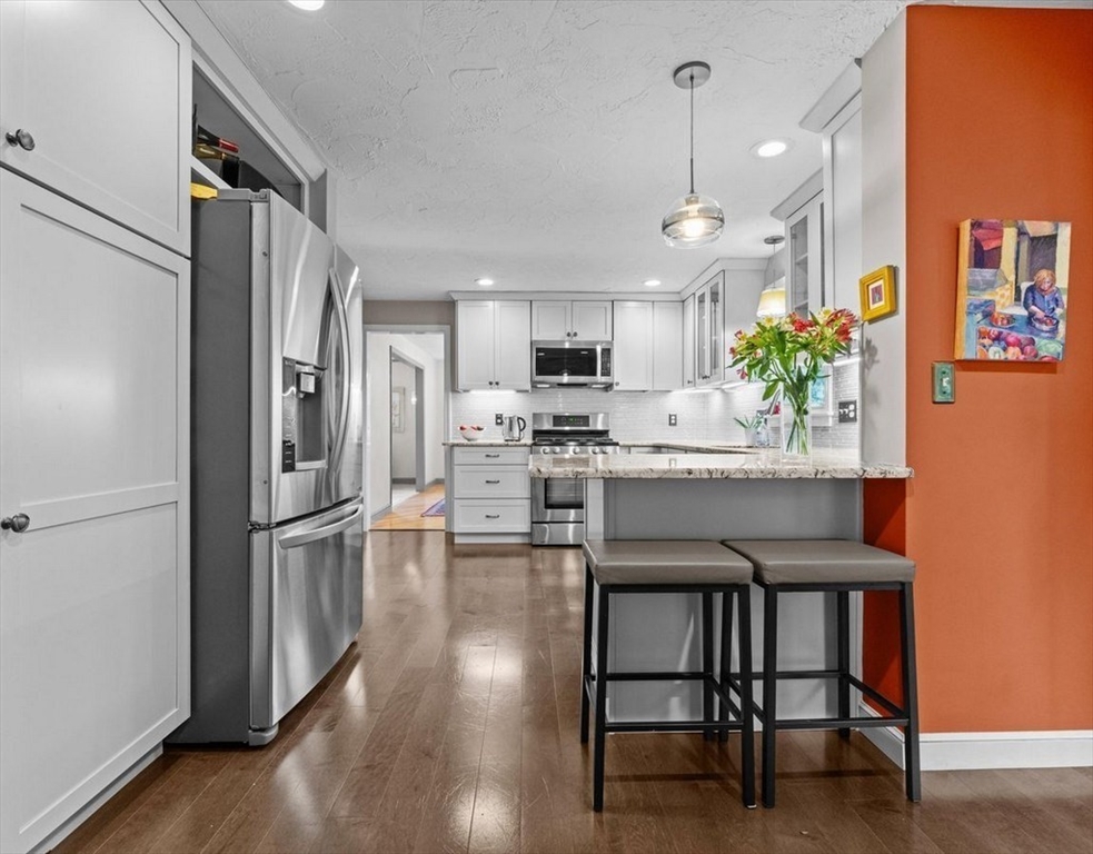 9 Pleasantview Terrace Framingham, MA 01701 - Photo 3 of 35 a kitchen with stainless steel appliances granite countertop a refrigerator a sink dishwasher a stove a dining table and chairs with wooden floor