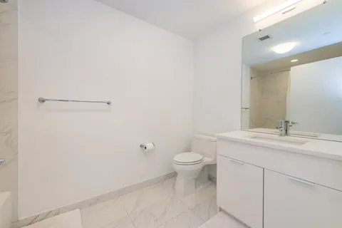 a bathroom with a toilet a sink and mirror
