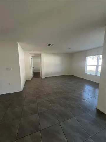 a view of empty room with window and wooden floor