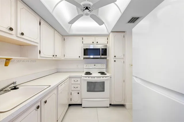 a kitchen with white cabinets and white appliances