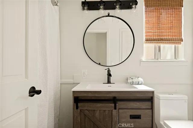 a bathroom with a sink a mirror and a toilet