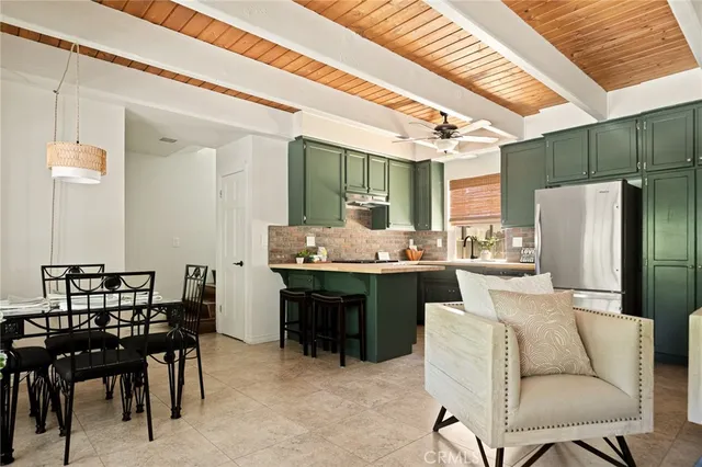 a kitchen with a table chairs refrigerator and cabinets