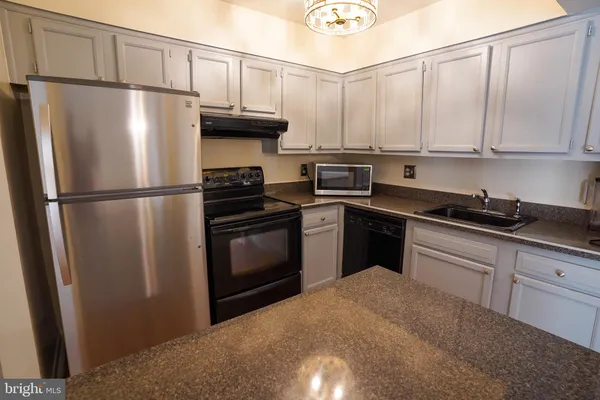 a kitchen with a refrigerator sink and cabinets