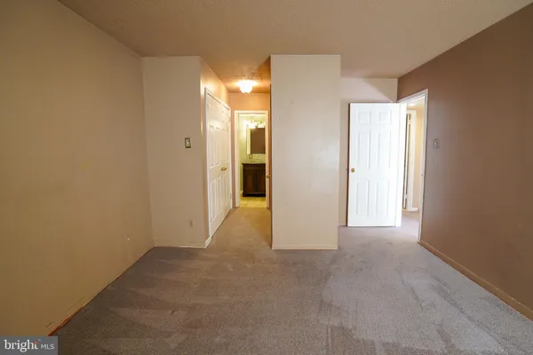 a view of a bathroom with closet and mirror