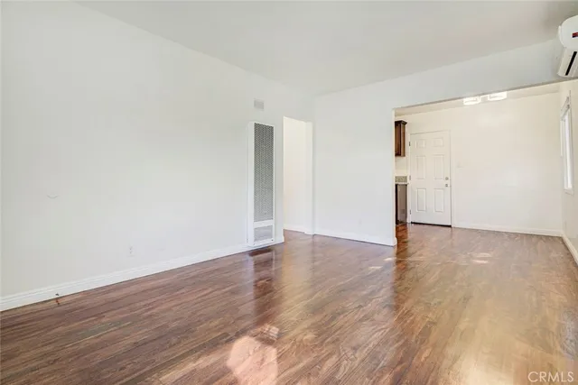 a view of a kitchen with wooden floor and a window