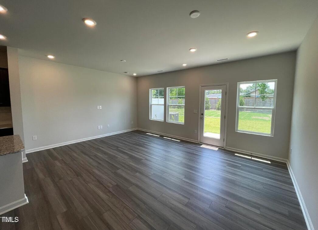 244 Paramount Drive Smithfield, NC 27577 - Photo 10 of 16 an empty room with wooden floor and windows