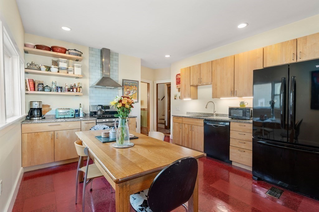 89 Bromfield Road Somerville, MA 02144 - Photo 15 of 41 a kitchen with stainless steel appliances granite countertop a refrigerator a sink dishwasher a stove a dining table and chairs with wooden floor