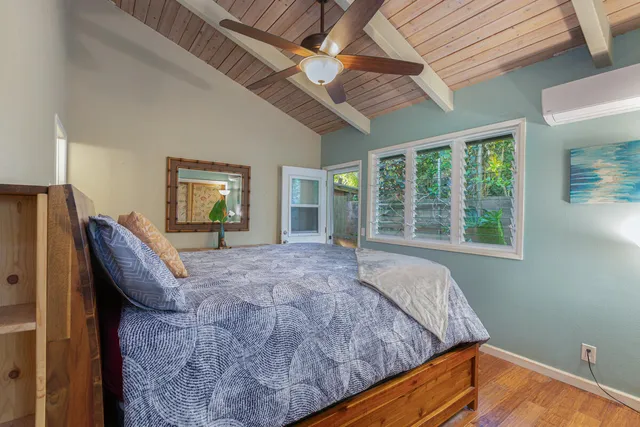 a bed sitting in a spacious bedroom next to a window