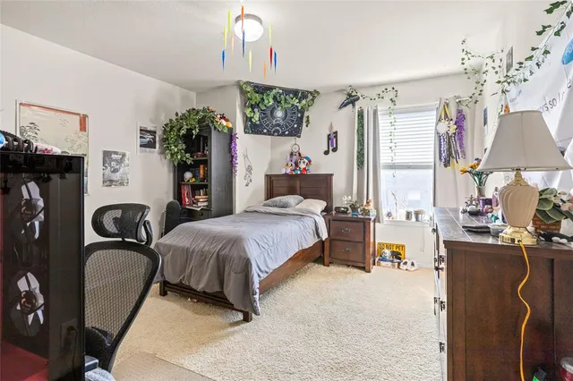 a bedroom with a bed dresser and a table