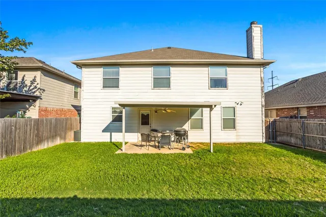 a view of a house with backyard and a tree