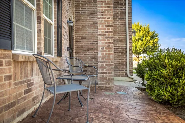 a patio with table and chairs and potted plants