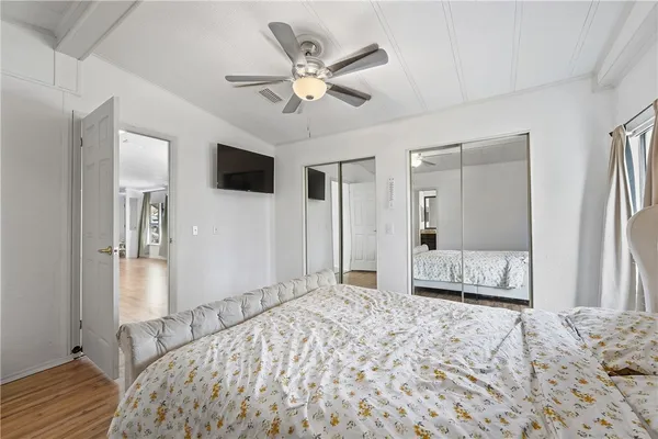 a bedroom with a bed and a large mirror with a flat tv screen