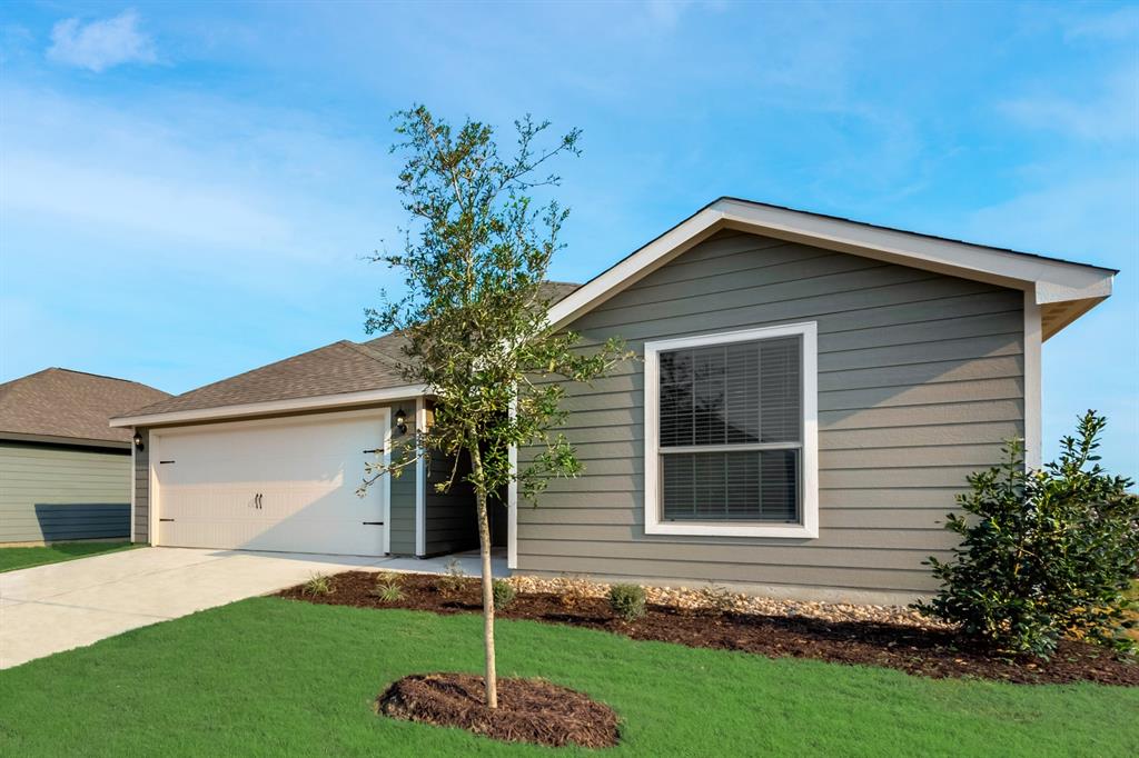 a front view of a house with a garden and yard