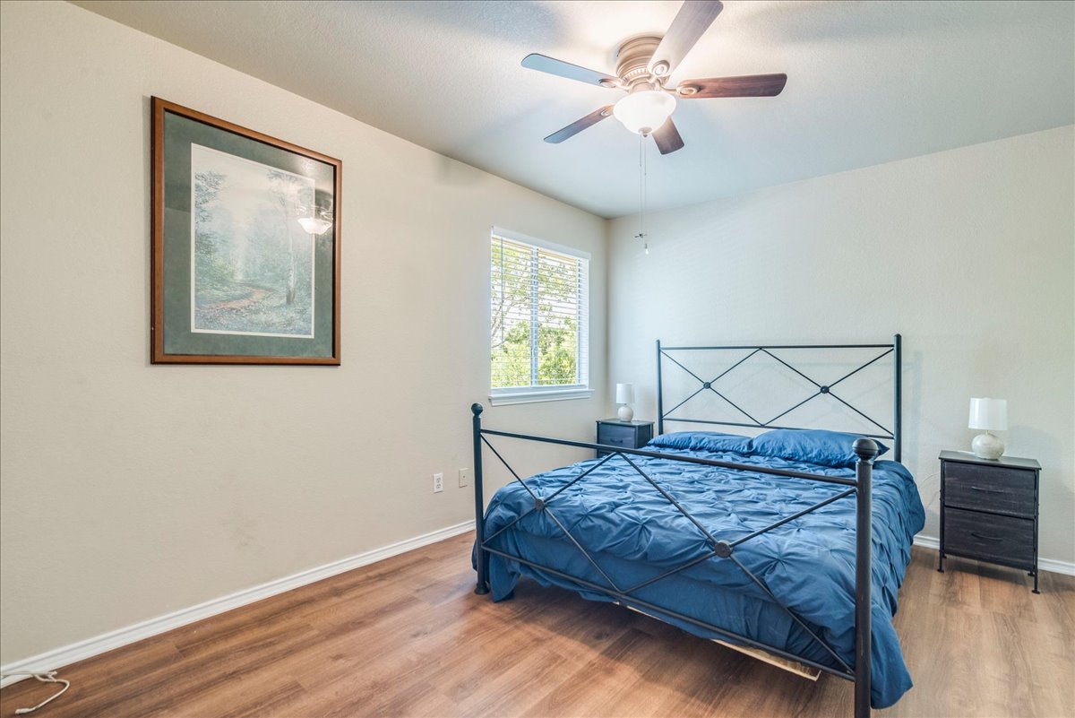 9300 Tea Rose Trail Austin, TX 78748 - Photo 25 of 33 A well-lit bedroom features hardwood floors and a ceiling fan for comfort.