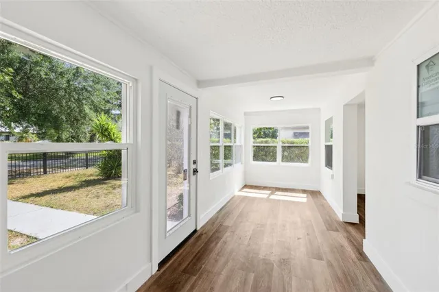 a big room with wooden floor and a bathroom