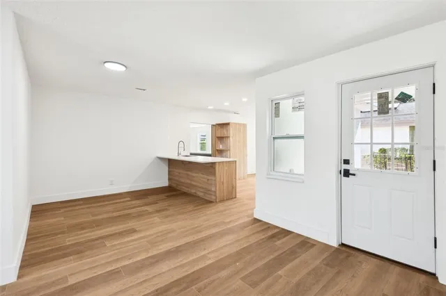 a view of empty room with wooden floor and window