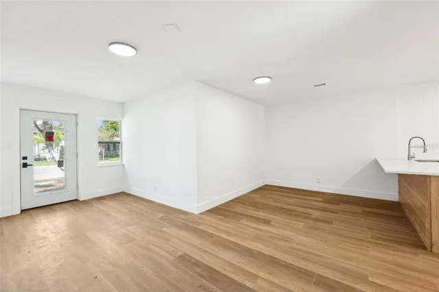 a view of a big room with wooden floor and windows